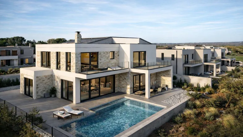 Moderne Villa mit privatem Pool, großzügiger Terrasse und Balkonen in einer Wohnanlage mit Blick ins Grüne.