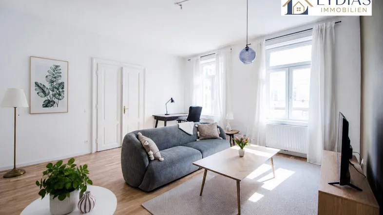Helles Wohnzimmer mit modernem Sofa, Holzboden und Blick nach draußen.