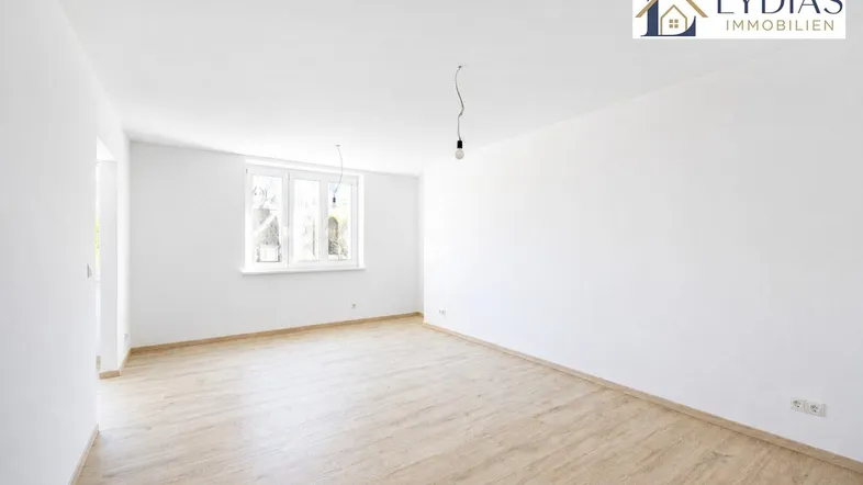 Helles, unmöbliertes Zimmer mit Laminatboden und großen Fenstern, bereit zur individuellen Gestaltung.