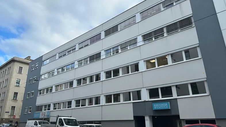 Mehrstöckiges Bürogebäude mit vielen Fenstern und einem Schild "Bürocenter Wienzeile" an der Fassade.