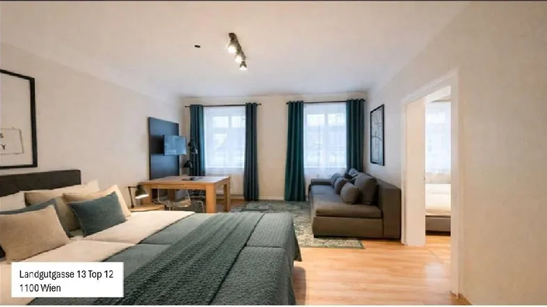 Helles Studio-Apartment mit Schlafbereich, Sofa und Esstisch, ausgestattet mit modernen Möbeln und Holzboden.