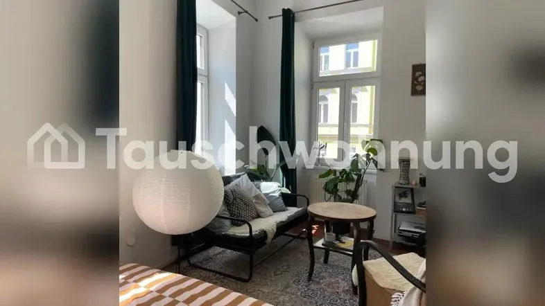 Helles Schlafzimmer mit gemütlicher Sitzecke, großen Fenstern und Blick ins Grüne.