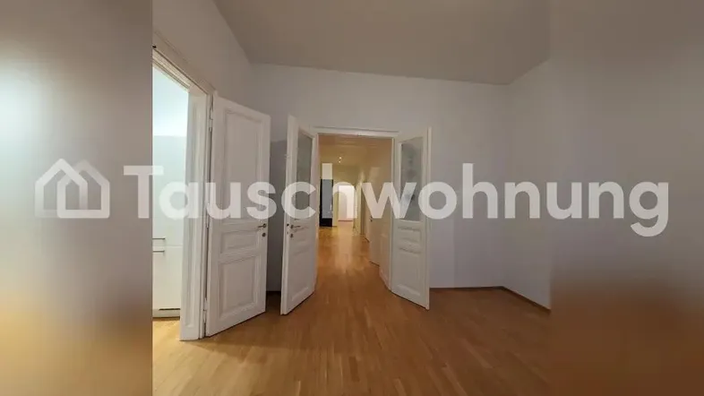 Geräumiger Innenraum mit Holzboden und mehreren Türen, die zu anderen Zimmern führen.