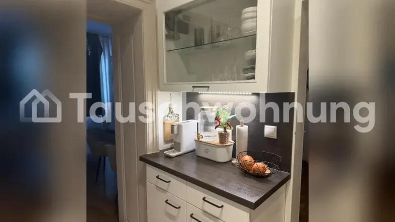 Kleine Küchenzeile mit Kaffeemaschine und Stauraum, ideal für eine kompakte Wohnung.