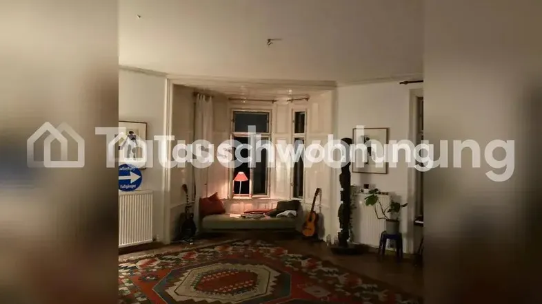 Gemütliches Wohnzimmer mit Erkerfenster, Holzboden und einem großen Teppich.