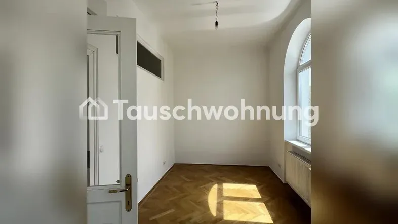 Helles Zimmer mit Fischgrätparkett und Bogenfenster, ideal als Wohn- oder Schlafzimmer.