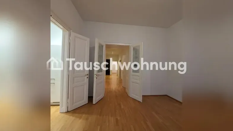 Geräumiger Flur mit hellem Parkettboden, hohen Decken und klassischen weißen Türen.