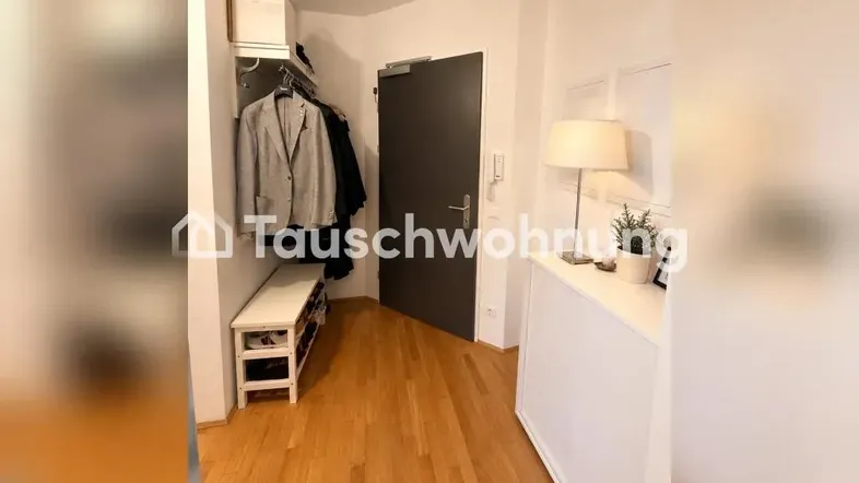 Heller Eingangsbereich mit Garderobe, Sitzbank und Holzboden, der einen einladenden Empfang bietet.