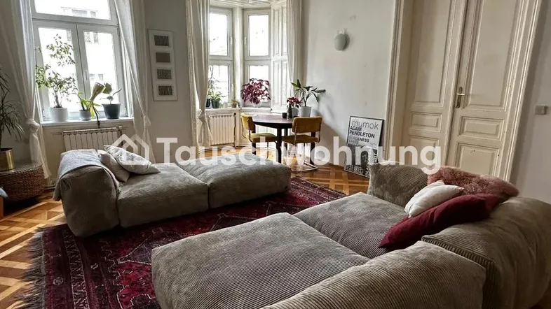 Geräumiges Wohnzimmer mit bequemen Sofas, Parkettboden und einem hellen Erkerbereich.
