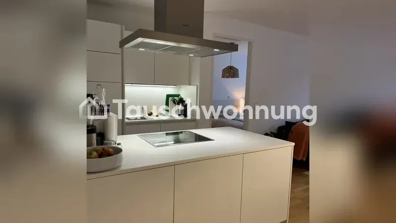 Moderne Küche mit Kochinsel, Induktionskochfeld und Dunstabzugshaube in hellem Design.