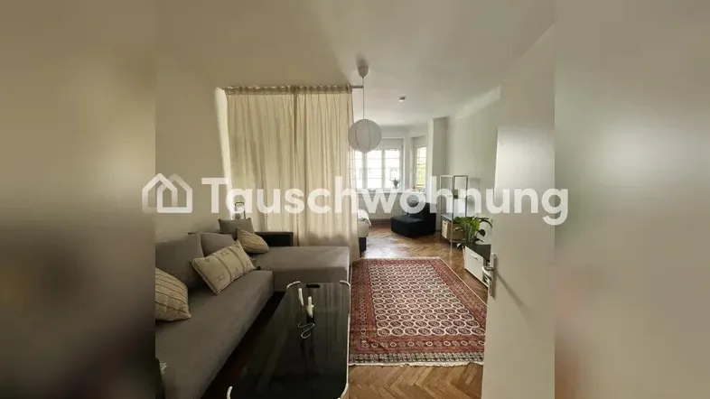 Gemütliches Wohnzimmer mit L-förmigem Sofa, Couchtisch und Fischgrätparkettboden.