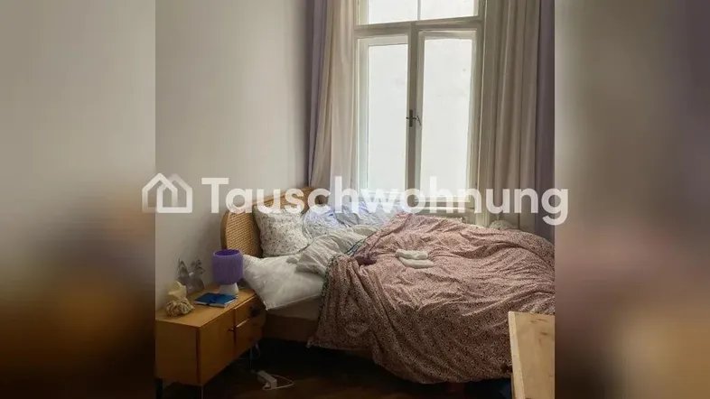Helles Schlafzimmer mit Parkettboden, einem Einzelbett und einem großen Fenster.