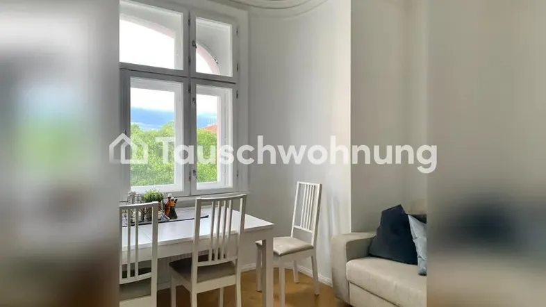 Heller Wohn- und Essbereich mit Parkettboden, Stuckdecke und Blick ins Grüne.