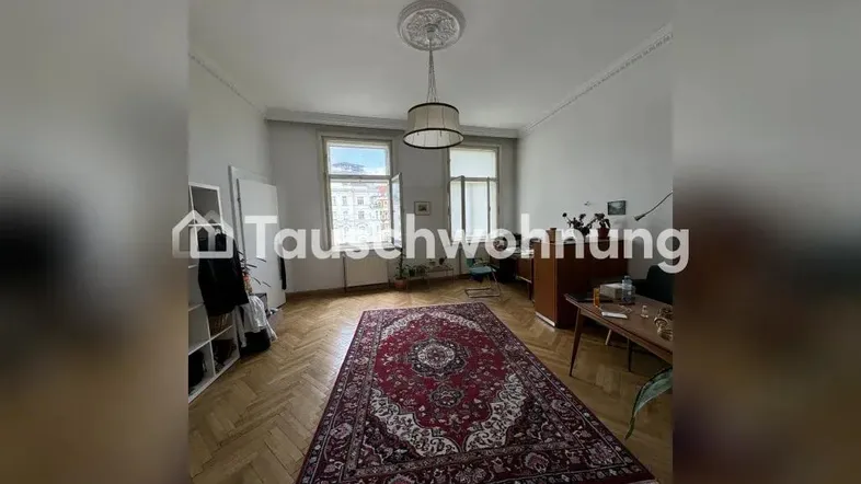 Helles Wohnzimmer mit Fischgrätparkett, Stuckdecke und großem Orientteppich.