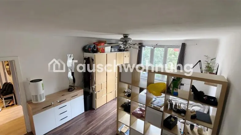Geräumiger Wohnbereich mit Bett, Regal als Raumteiler und Fenster für natürliches Licht.