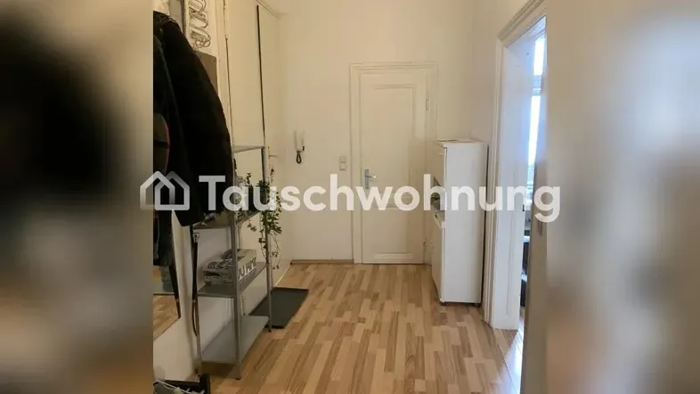 Heller Flur mit Laminatboden, Garderobe und weißer Eingangstür, der einen einladenden ersten Eindruck vermittelt.