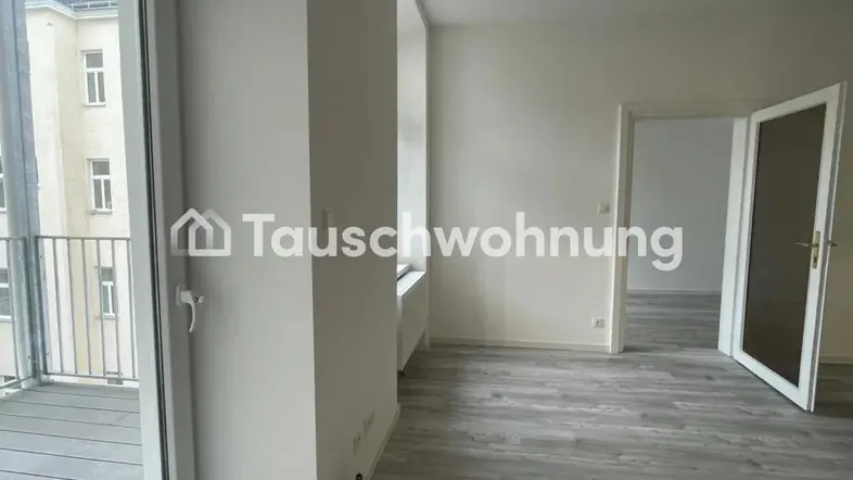 Heller, unmöblierter Raum mit modernem Laminatboden und direktem Zugang zu einem Balkon.