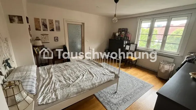 Helles Schlafzimmer mit Holzboden, einem Doppelbett und einem Fenster mit Blick nach draußen.