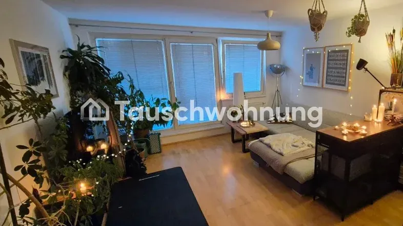 Gemütliches Wohnzimmer mit Holzboden, großen Fenstern und vielen Pflanzen, dekoriert mit warmem Licht.