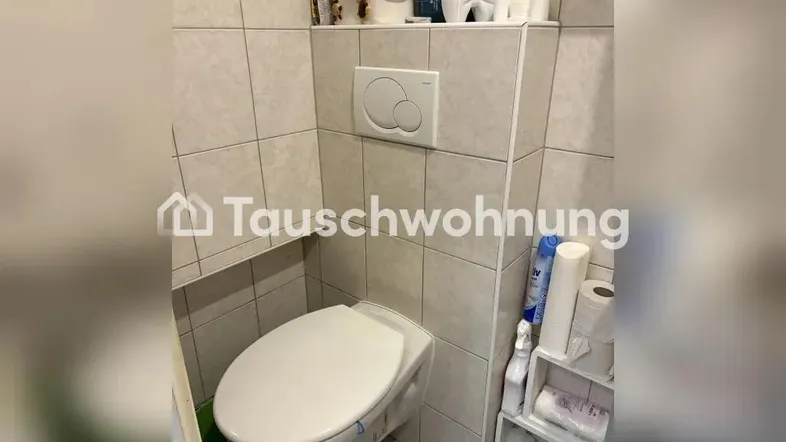 Kleines Gäste-WC mit wandhängender Toilette und hellen Fliesen an den Wänden.