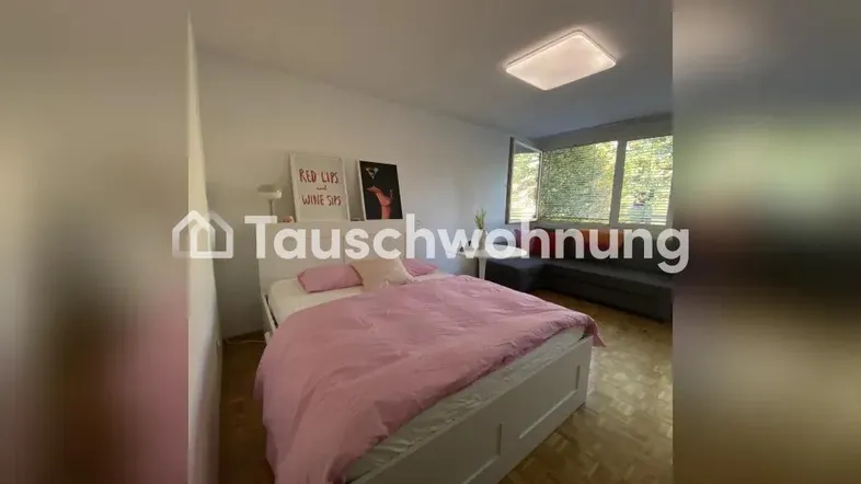 Helles Schlafzimmer mit großem Bett, Parkettboden und Fensterfront mit Blick ins Grüne.