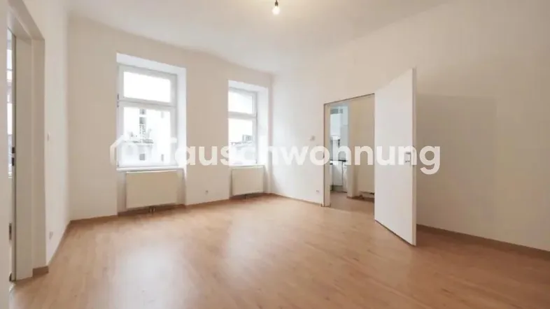 Helles, leeres Zimmer mit Parkettboden und zwei Fenstern, bereit zur individuellen Gestaltung.