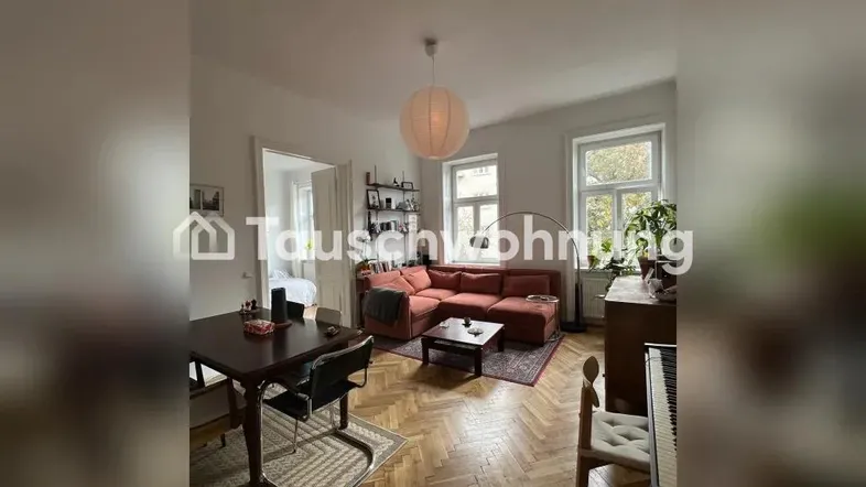 Helles Wohn- und Esszimmer mit Fischgrätparkett, bequemer Couch und Esstisch für gesellige Stunden.