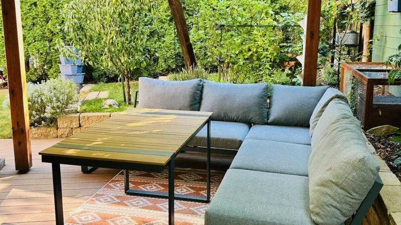 Gemütliche Terrasse mit bequemen Loungemöbeln und üppigem Grün im Hintergrund, ideal zum Entspannen.