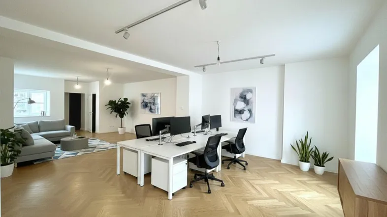 Geräumiges Büro mit modernem Design, Fischgrätparkett und integriertem Loungebereich, ideal für produktives Arbeiten.