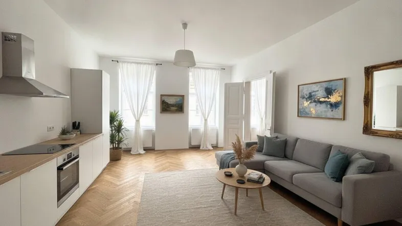 Heller offener Wohnbereich mit integrierter Küche, Fischgrätparkett und modernem Sofa.