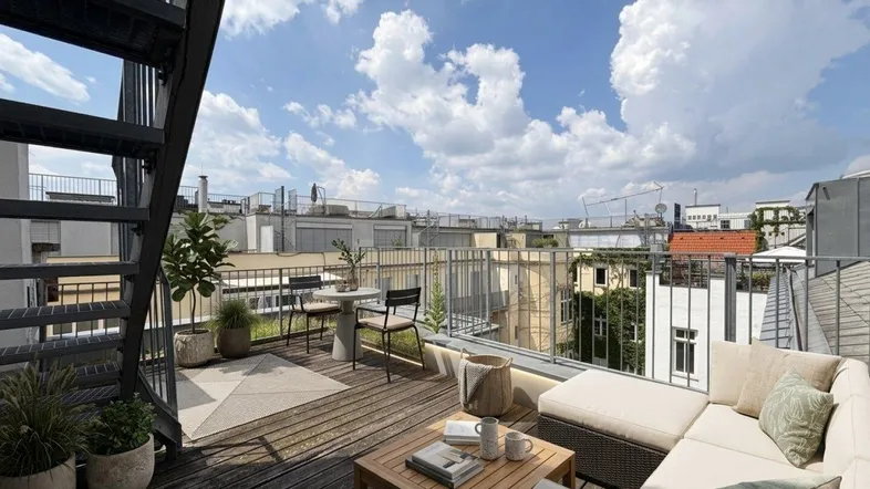 Möblierte Dachterrasse mit Lounge-Bereich, Pflanzen und weitem Blick über die Stadt.