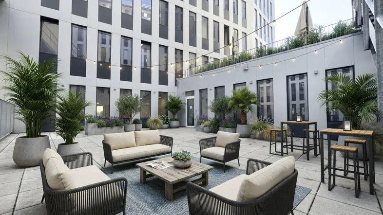Gemütlicher Innenhof mit modernen Lounge-Möbeln und Pflanzen, ideal zum Entspannen im Freien.