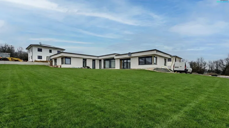 Modernes Einfamilienhaus mit großer Rasenfläche und Neubaucharakter in ländlicher Umgebung.