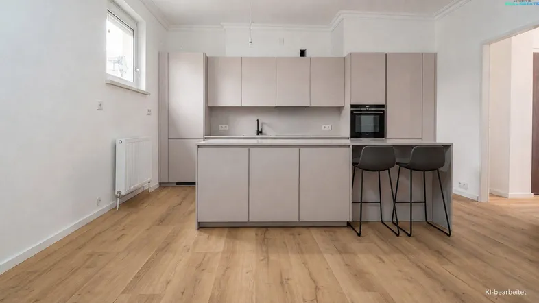 Moderne Küche mit hellen Schränken, Kochinsel und Holzboden in einem offenen Raum.