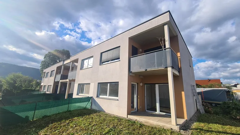 Modernes Mehrfamilienhaus mit Balkonen und Terrassen in sonniger Lage und grüner Umgebung.