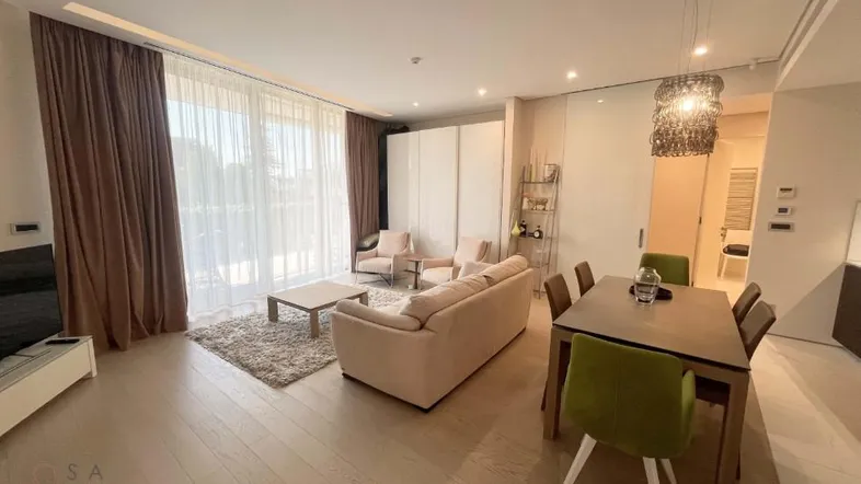 Heller, offener Wohn- und Essbereich mit Holzboden und Zugang zu einem Balkon.