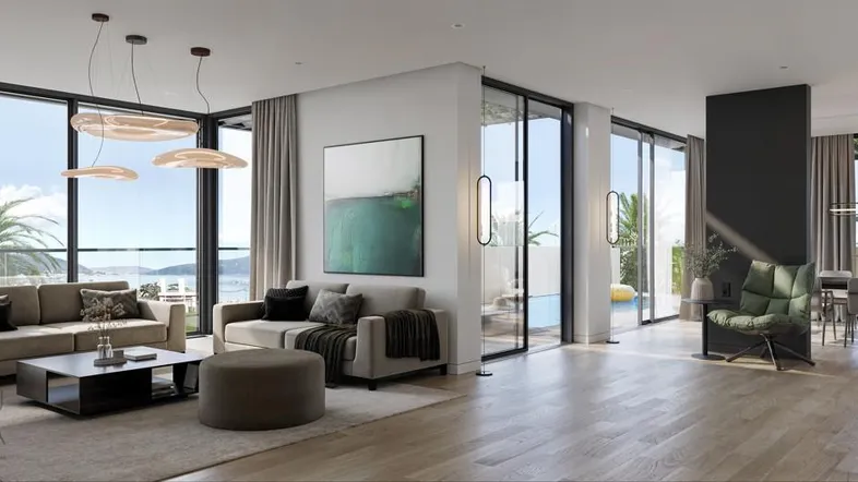 Modernes Wohnzimmer mit großen Fenstern, Meerblick und offenem Essbereich.
