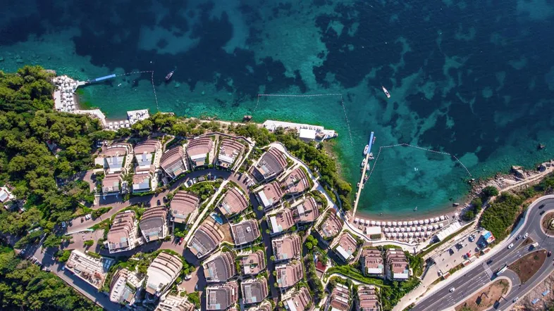 Spektakuläre Luftaufnahme der luxuriösen Wohnanlage mit Privatstrand und kristallklarem Meer.