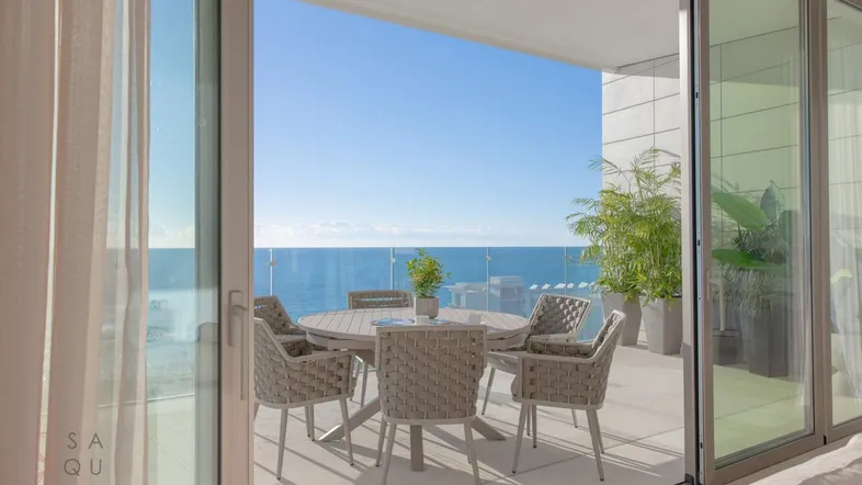 Geräumige Terrasse mit Meerblick, Esstisch und bequemen Sitzgelegenheiten, ideal für entspannte Stunden im Freien.