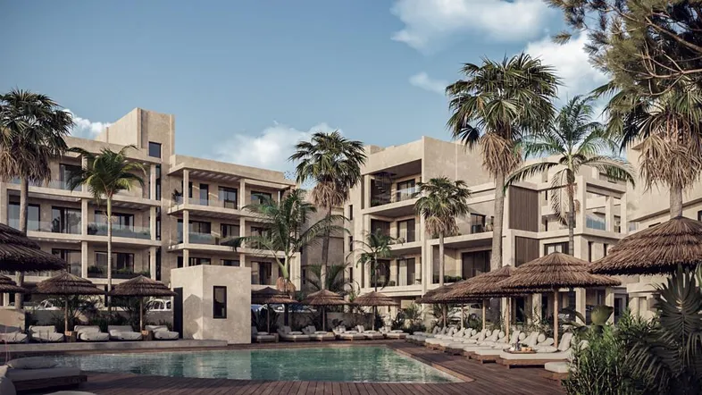 Moderne Apartmentanlage mit großem Poolbereich, Palmen und Liegestühlen unter Sonnenschirmen.
