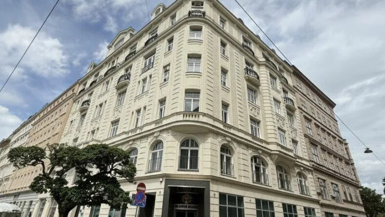 Ornate Fassade eines Eckgebäudes mit klassischen architektonischen Details und Fahrrädern davor.