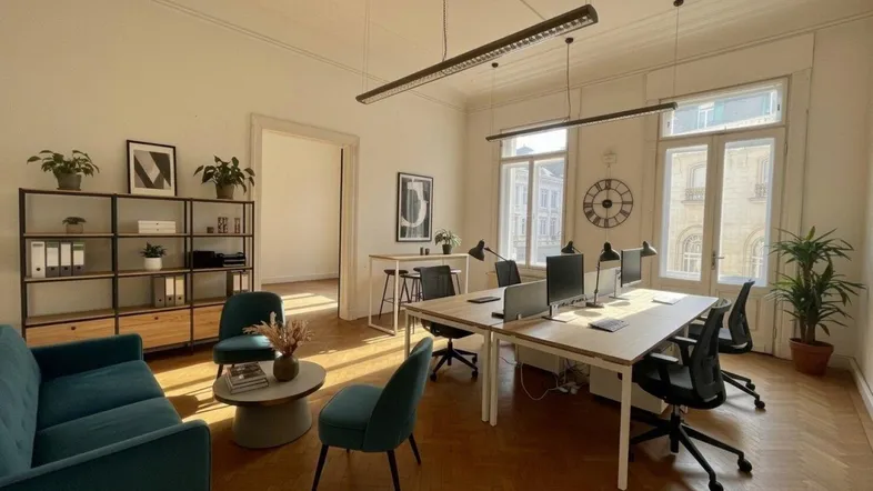 Helles, modernes Büro mit mehreren Arbeitsplätzen, Lounge-Bereich und Fischgrätparkettboden.