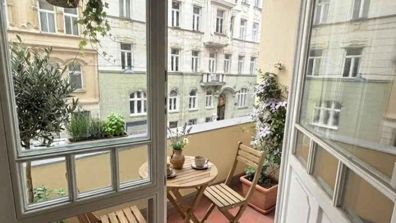Gemütlicher Balkon mit Sitzgelegenheiten und Blick auf die umliegenden Gebäude.