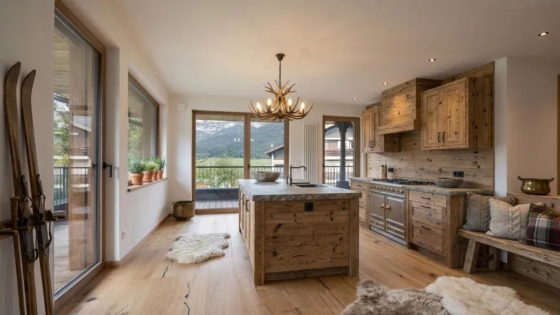 Gemütliche Küche im alpinen Stil mit Holzelementen, Kücheninsel und beeindruckendem Bergblick.