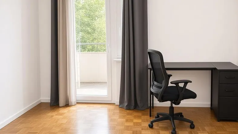 Helles Zimmer mit Parkettboden, Balkonzugang und einem Schreibtisch.
