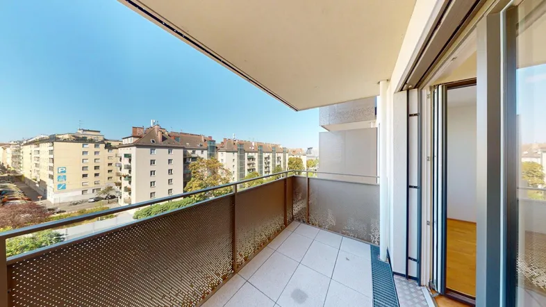 Geräumiger Balkon mit Fliesenboden und Blick auf die umliegende Stadtbebauung.