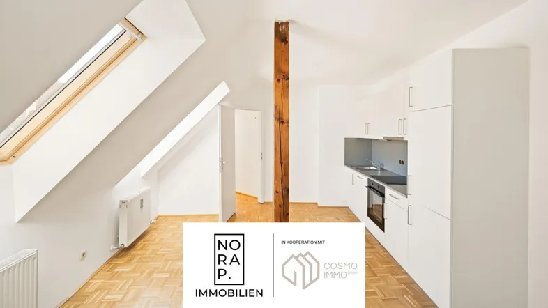 Helles Dachgeschosszimmer mit kleiner Einbauküche, Parkettboden und Dachfenstern.