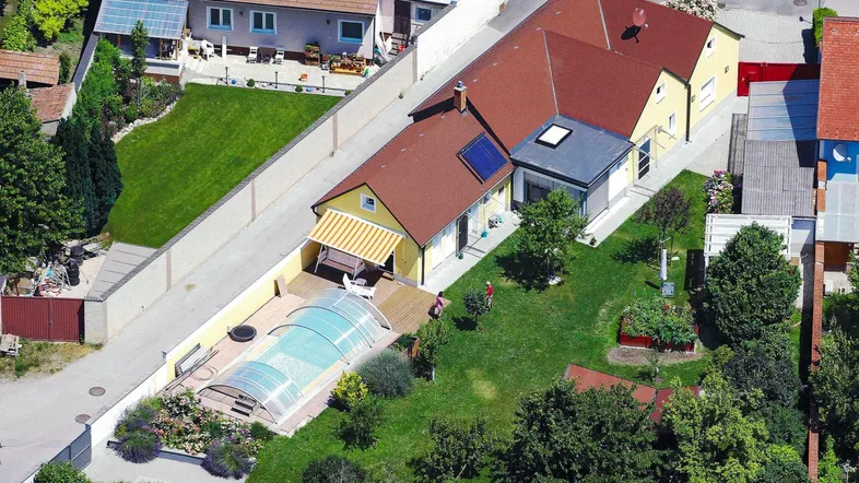 Luftaufnahme des Anwesens mit Haus, Garten, Pool und umliegender Bebauung in ländlicher Umgebung.