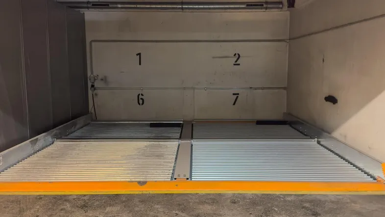Mechanisches Doppelparkersystem in einer Tiefgarage mit nummerierten Stellplätzen für effizientes Parken.