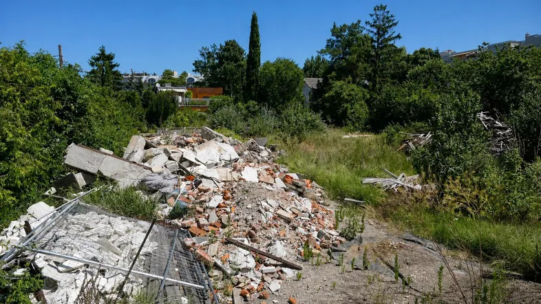 Grundstück mit Bauschutt und Vegetation, bereit für eine neue Entwicklung oder Sanierung.